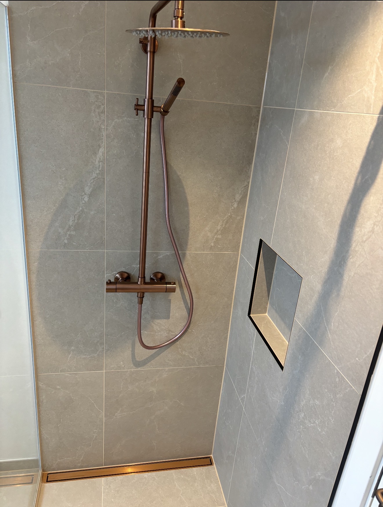 Bruseafsnit med stort rain shower og marmorfliser